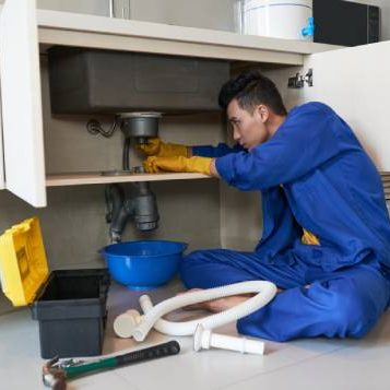 asian-plumber-blue-overalls-clearing-blockage-drain (1)